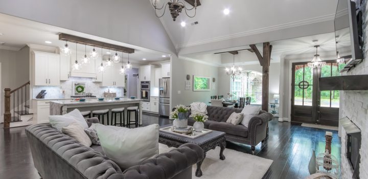 Stylish living room decorated in neutral tones, showcasing a modern fireplace, plush furnishings, and decorative lighting that adds a touch of elegance.