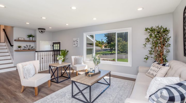 Contemporary living room design featuring minimalist furniture, bright natural lighting through large windows, and a serene neutral color palette.